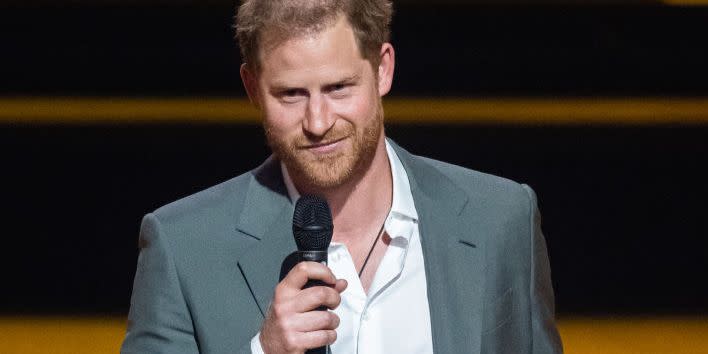 prince harry speaks during an invictus games opening ceremony on stage in a grey suit