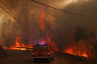 Firefighters drive through smoke from a forest fire in Chaveira