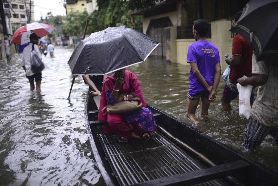 A woman sits in a country boat as it moves through flood waters in Sylhet, Bangladesh, Monday, June 20, 2022. Floods in Bangladesh continued to wreak havoc Monday with authorities struggling to ferry drinking water and dry food to flood shelters across the country’s vast northern and northeastern regions. (AP Photo/Mahmud Hossain Opu)