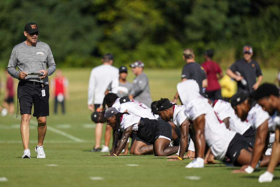 Washington Commanders head coach Ron Rivera, left, surveys his team during NFL football training camp, Thursday, July 28, 2022 in Ashburn, Va. (AP Photo/Alex Brandon)