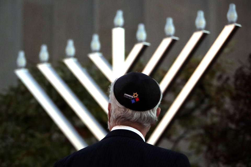 Rabbi Jeffrey Myers watches the installation of a menorah outside the Tree of Life Synagogue before holding a celebration on the first night of Hanukkah, Sunday, Dec. 2, 2018, in the Squirrel Hill neighborhood of Pittsburgh. A gunman shot and killed 11 people while they worshipped Saturday, Oct. 27, at the temple. (AP Photo/Gene J. Puskar)