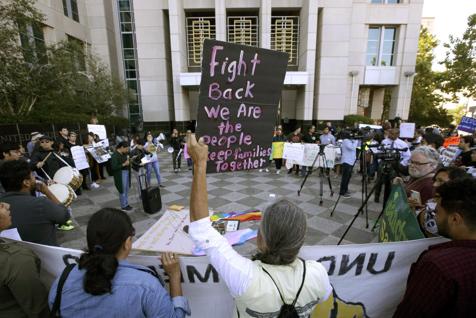 FILE - In this June 20, 2018, file photo, protesters demonstrate outside the federal courthouse in Sacramento, Calif., where a judge heard arguments over the U.S. Justice Department's request to block three California laws that extend protections to people in the country illegally. The Justice Department told The Associated Press at the end of February 2019 that 28 jurisdictions, including Sacramento, that were targeted in 2017 over what it considered "sanctuary" policies have been cleared for law enforcement grant funding. (AP Photo/Rich Pedroncelli, File)
