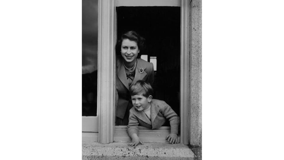 The late Queen and Charles leaning out of a window at Balmoral Castle, Scotland in 1952