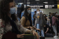 People wait at the check in for a flight to Dusseldorf, Germany, at Rome's Fiumicino airport, Wednesday, June 3, 2020. Italians and other EU citizens who got stuck in Italy during the coronavirus lockdown can now fly to European countries without restrictions and mandatory 14 days quarantine. (AP Photo/Alessandra Tarantino)