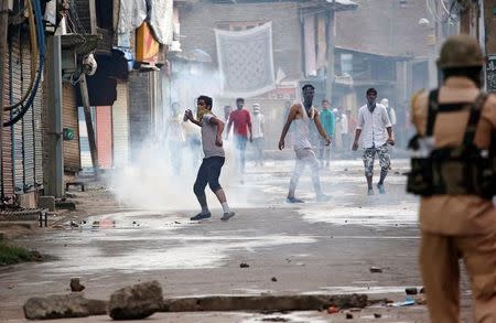 A protester throws back a tear gas shell fired by police during a protest in Srinagar against the recent killings in Kashmir August 26, 2016. REUTERS/Danish Ismail/Files