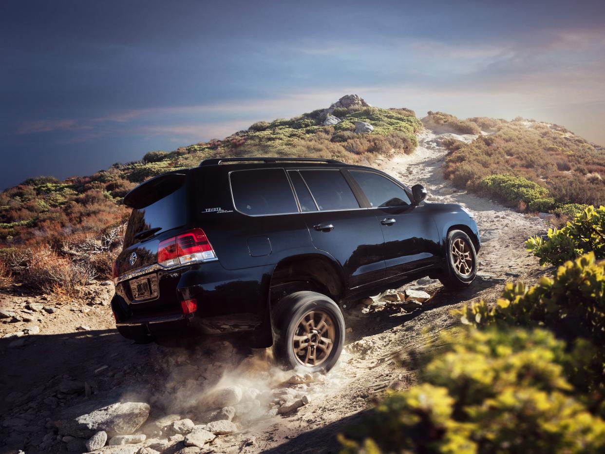 Black 2021 Toyota Land Cruiser driving over rough terrain