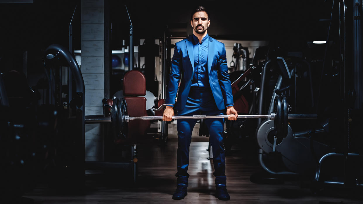  Man in suit lifting heavy weight. 