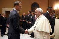 Pope Francis shakes hand with Bayern Munich's Manuel Neuer during a private audience with the Bayern Munich soccer team at the Palace of the Vatican in Vatican City, October 22, 2014. REUTERS/Alexander Hassenstein