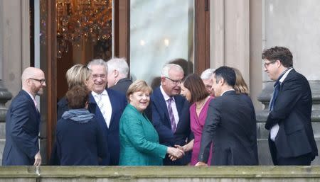 Leader of the German Green Party Cem Ozdemir and leader of the Christian Democratic Union of Germany (CDU) Angela Merkel accompanied by the politicians of their parties are seen on the balcony of German Parliamentary Society offices prior to the exploratory talks about forming a new coalition government held by CDU/CSU in Berlin, Germany, October 18, 2017. REUTERS/Fabrizio Bensch