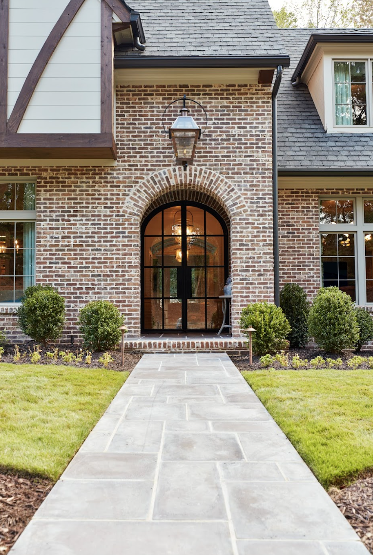 a brick house with a large front door and a stone walkway