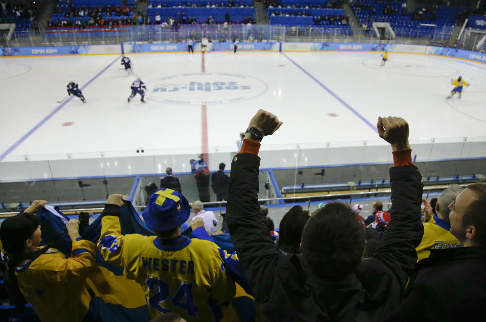 Fans cheer at the start of play between Sweden and the USA during a 2014 Winter Olympics women's semifinal ice hockey game at Shayba Arena Monday, Feb. 17, 2014, in Sochi, Russia. (AP Photo/Matt Slocum)