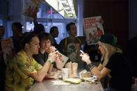 Patrons sit as their lunch is interrupted by demonstrators in Chipotle Mexican Grill during a strike aimed at the fast-food industry and the minimum wage in Seattle, Washington August 29, 2013. Fast-food workers went on strike and protested outside restaurants in 60 U.S. cities on Thursday, in the largest protest of an almost year-long campaign to raise service sector wages. REUTERS/David Ryder (UNITED STATES - Tags: BUSINESS FOOD EMPLOYMENT CIVIL UNREST)