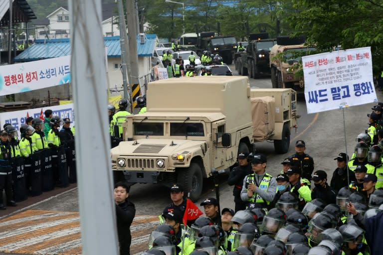 Protesters and police stand by as trailers carrying US THAAD missile defence equipment enter a deployment site in Seongju, South Korea, on April 26, 2017