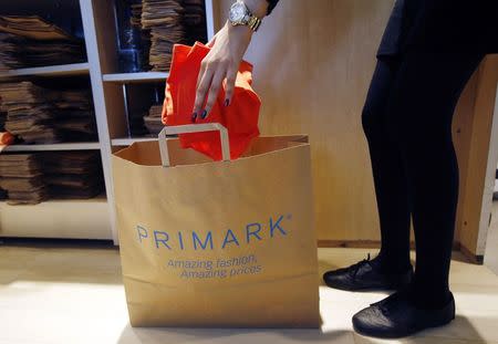 A sales assistant packs clothes at a Primark store on Oxford Street in London June 20, 2014. REUTERS/Luke MacGregor