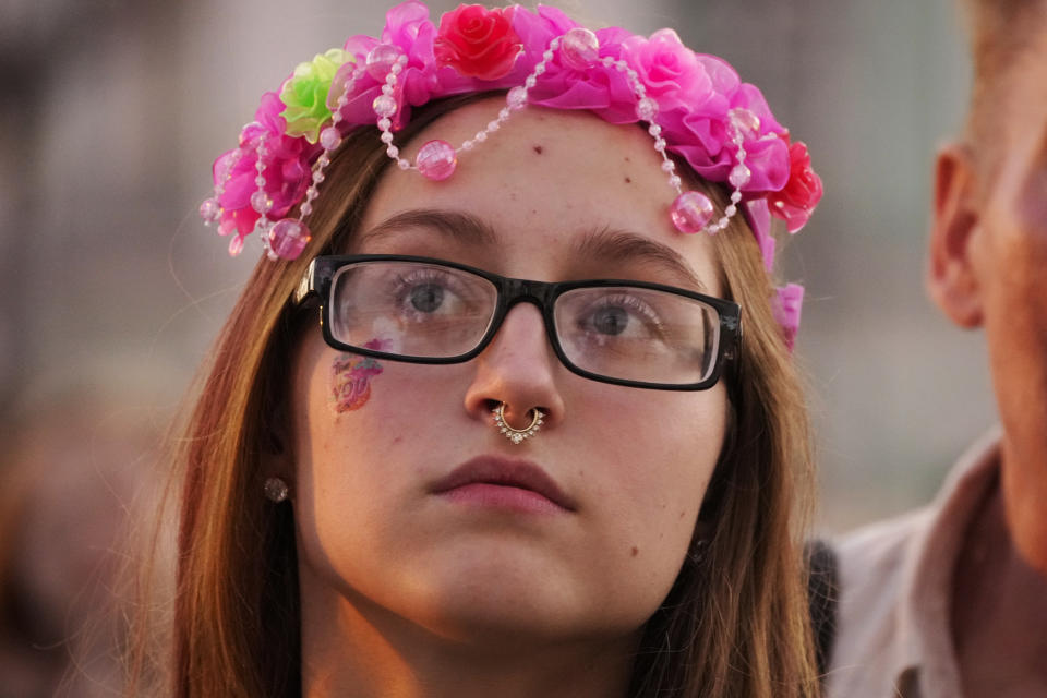 A school graduate watches a concert in the Palace Square during the Scarlet Sails festivities marking school graduation in St. Petersburg, Russia, Friday, June 24, 2022. The Scarlet Sails celebration is a rite of passage both figuratively and literally. Every year, tall ships with glowing red sails make their way down the Neva River in St. Petersburg to honor recent school graduates as they set out on the journey into adulthood. (AP Photo/Dmitri Lovetsky)