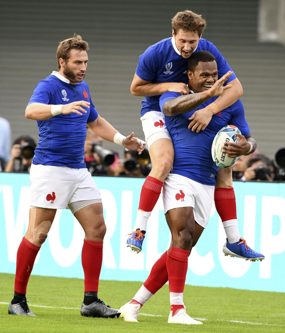 France's Virimi Vakatawa is congratulated by teammates after scoring a try during the Rugby World Cup Pool C game at Kumamoto Stadium between France and Tonga in Kumamoto, Japan, Sunday, Oct. 6, 2019.(Kyodo News via AP)