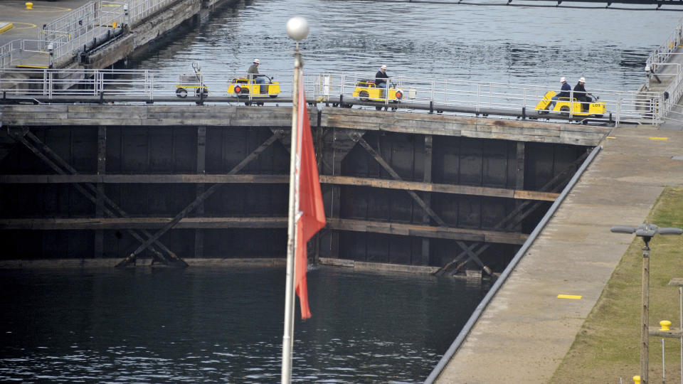 FILE - Workers use scooters across the closed gate of the MacArthur lock on April 18, 2016, at the Soo Locks outside Sault Ste Marie, Mich. President Joe Biden signed on Friday, Dec. 23, 2022, a large defense bill that includes the Water Resources Development Act of 2022. The water legislation sets out new infrastructure projects for the Army Corps of Engineers to build, including a new Soo Lock. (Dale G. Young/Detroit News via AP, File)