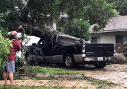 <p>An unidentified man looks at a truck that was crushed by a falling tree in Fort Walton Beach, Florida on June 21, 2017. (Photo: Tom Mclaughlin/Northwest Florida Daily News via AP) </p>