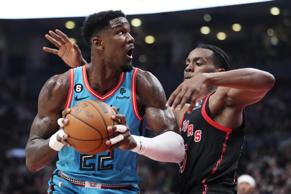 Phoenix Suns centre Deandre Ayton (22) protects the ball from Toronto Raptors center Christian Koloko, right, during first-half NBA basketball game action in Toronto, Friday, Dec. 30, 2022. (Frank Gunn/The Canadian Press via AP)