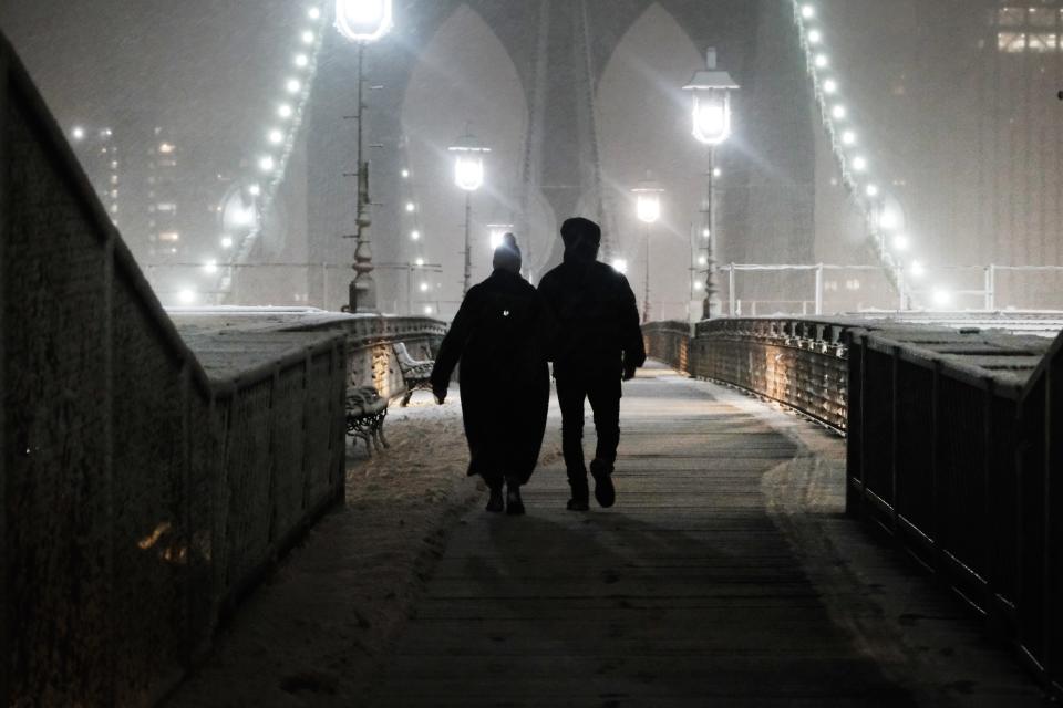 People walk across the Brooklyn Bridge during a storm on February 27, 2023 in New York City. Parts of northern New York City could see up to five inches of snow by morning in what would be the first real snowfall of the winter.