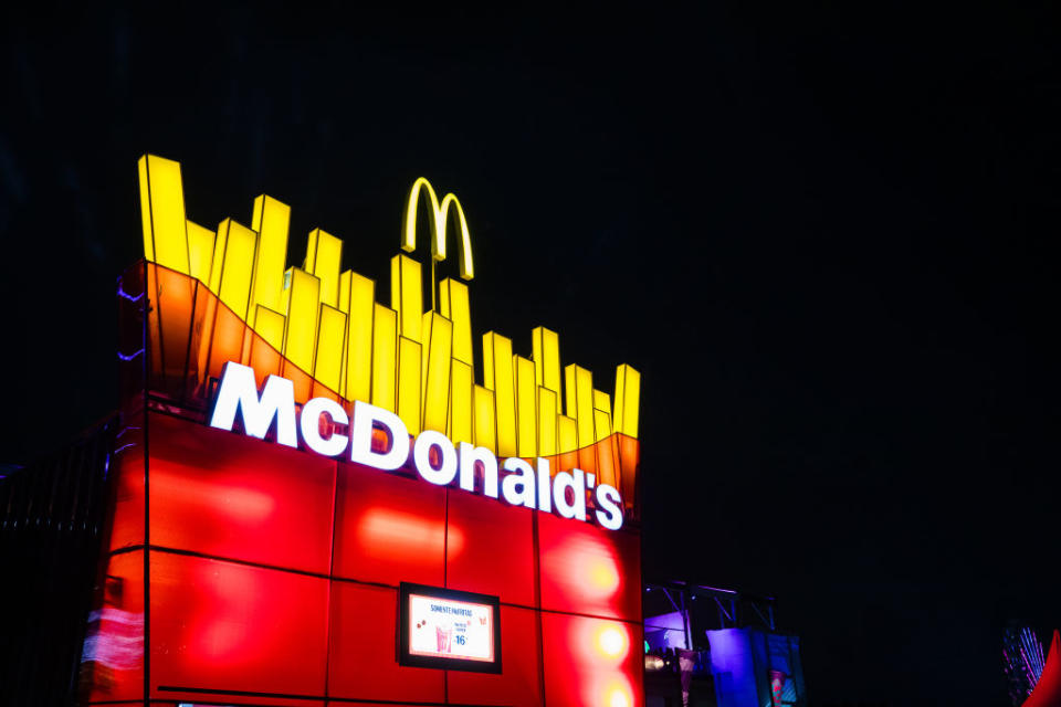 Neon-lit McDonald's sign with iconic golden arches at night