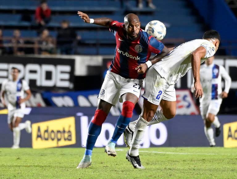 Herazo, el delantero colombiano que ocupó el lugar del suspendido Bareiro, en la lucha por la pelota con Pier Barrios