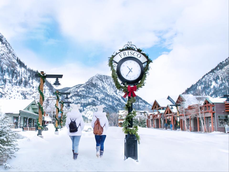 Girls enjoying beautiful Colorado mountain town on winter break. Snowcapped mountains and houses. Frisco, Colorado.