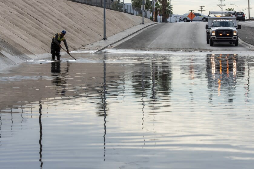 Un trabajador del Departamento de Transporte de Nevada labora para desaguar una inundación en la avenida West Washington, cerca de la calle North Main, el viernes 29 de julio de 2022, en Las Vegas. (Steel Brooks/Las Vegas Review-Journal vía AP)