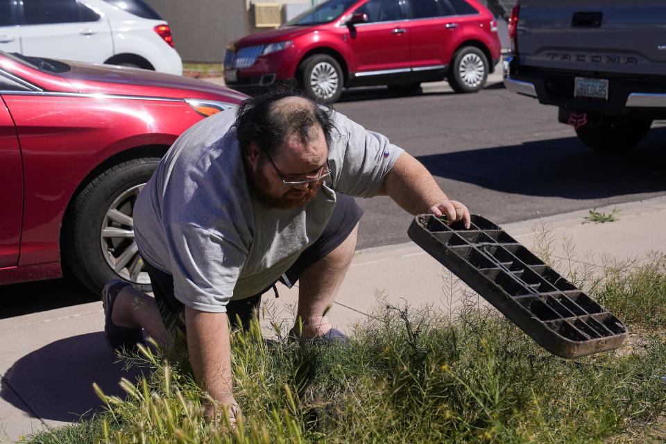 Tim Wiedman checks a water valve outside his mother's apartment at their home in Mesa.