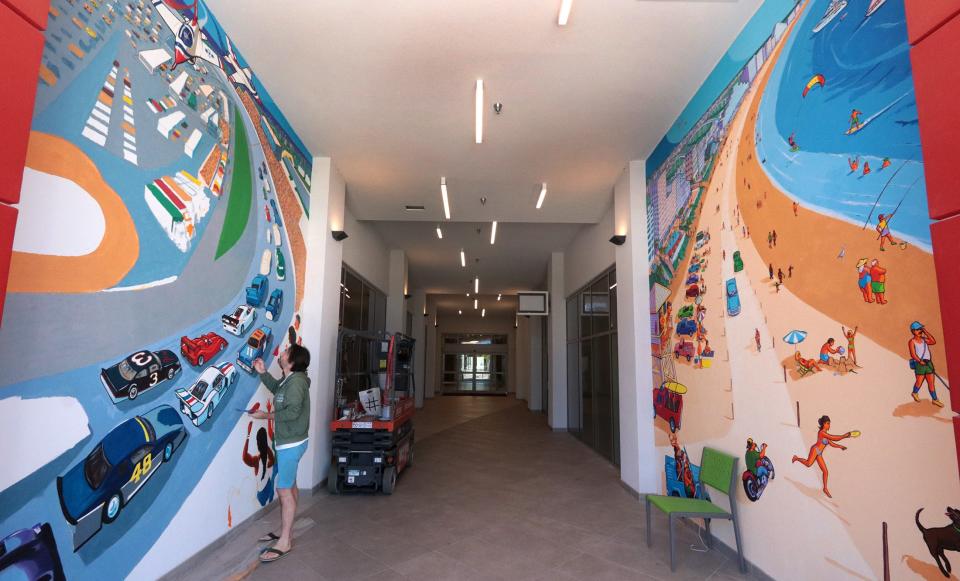 Artist Erwin Dazelle works on a racing themed mural with his Daytona Beach themed mural on the opposite wall, Tuesday November 16, 2021 in the Dayona Hotel at One Daytona.