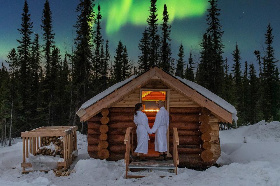 A couple walking into the sauna at Borealis Basecamp