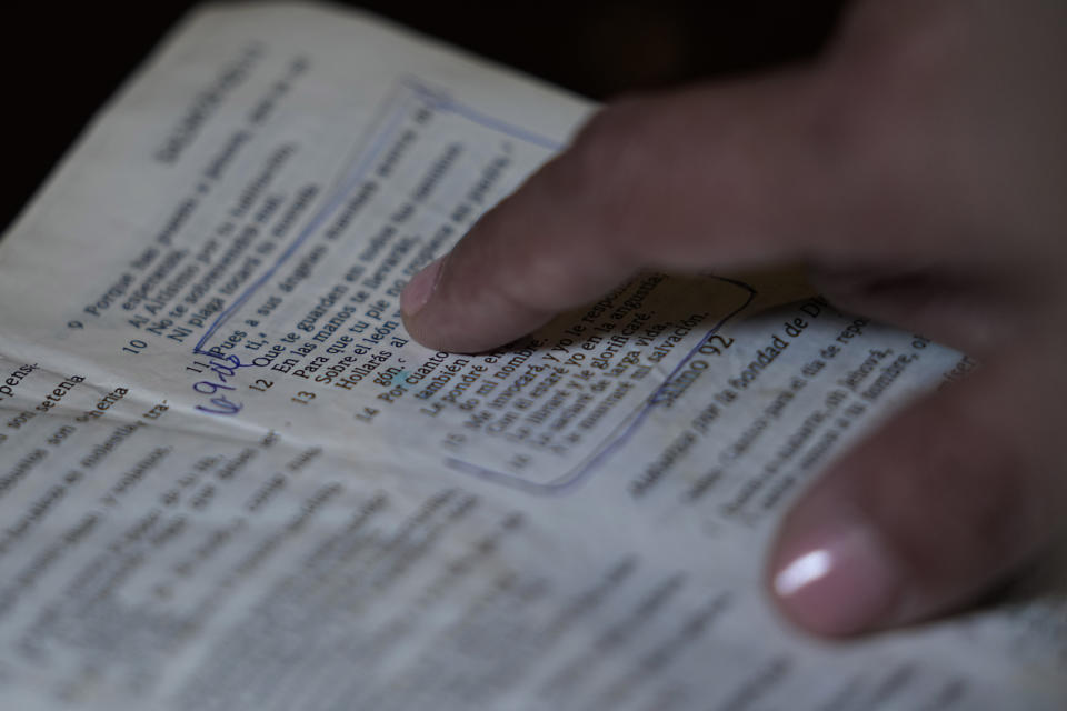 Irma Reyes points out scripture she uses to help herself deal with her daughter's ordeal with trafficking and the following trial at her South Texas home, Tuesday, Jan. 31, 2023. Reyes' daughter was one of two teens who men were accused of keeping at a San Antonio motel where other men paid to have sex with them in 2017. Their cases have seen years of delay, a parade of prosecutors, an aborted trial and, ultimately, a stark retreat by the government with the offer of a plea deal. (AP Photo/Eric Gay)