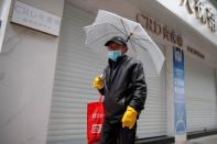 A man wears a face mask in a deserted shopping street in Jiujiang