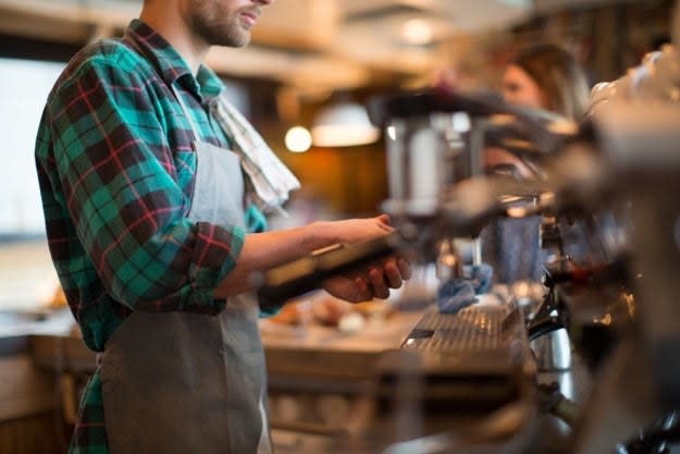 A man prepares an order in a coffee shop
