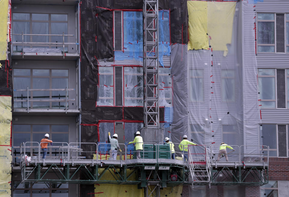 In this June 14, 2019 photo, construction workers perform tasks on an apartment building in Orlando, Fla. On Wednesday, July 17, the Commerce Department reports on U.S. home construction in June. (AP Photo/John Raoux)