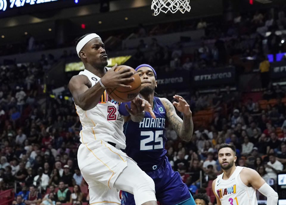Miami Heat forward Jimmy Butler (22) grabs a rebound from Charlotte Hornets forward P.J. Washington (25) during the first half of an NBA basketball game Thursday, Nov. 10, 2022, in Miami. (AP Photo/Marta Lavandier)