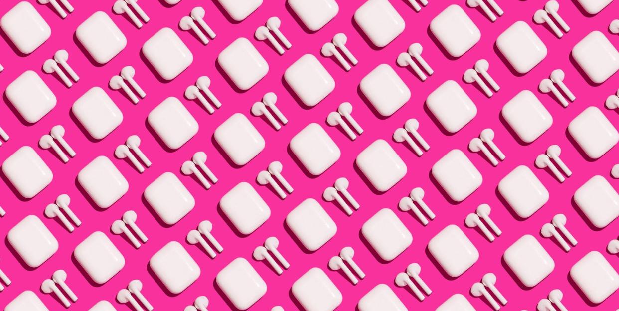 pattern of trendy wireless white headphones on fuchsia background