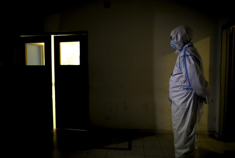 Un trabajador sanitario de pie ante el Hospital Llavallol Dr. Norberto Raúl Piacentini en Lomas de Zamora, Argentina, el sábado 1 de mayo de 2021, en medio de la nueva pandemia del coronavirus. Muchos médicos intentan abstraerse de esas disputas con olor electoralista y piden a los ciudadanos mayor responsabilidad individual para los infectados y muertos no sigan aumentando. (AP Foto/Natacha Pisarenko)