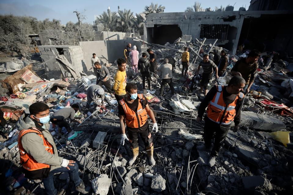 Palestinians inspect the damage of a destroyed house following Israeli airstrikes on Khan Younis, southern Gaza Strip, Sunday, Dec. 31, 2023.