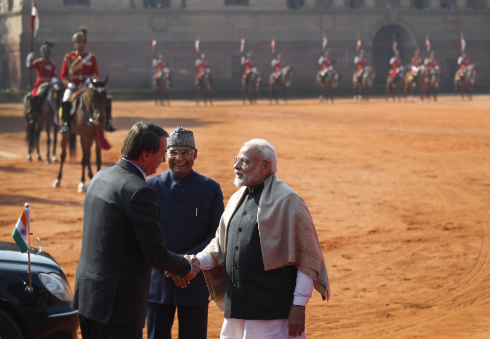 Brazil's President Jair Bolsonaro, left, shakes hand with Indian Prime Minister Narendra Modi, with Indian President Ram Nath Kovind standing beside them during his ceremonial welcome at the presidential palace in New Delhi, India, Saturday, Jan. 25, 2020. Bolsonaro is this year's chief guest for India's Republic day parade. (AP Photo/Manish Swarup)