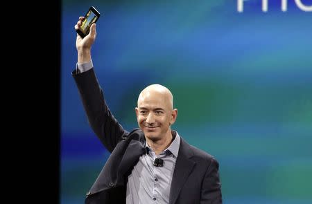 Amazon CEO Jeff Bezos shows off his company's new smartphone, the Fire Phone, at a news conference in Seattle, Washington June 18, 2014. REUTERS/Jason Redmond