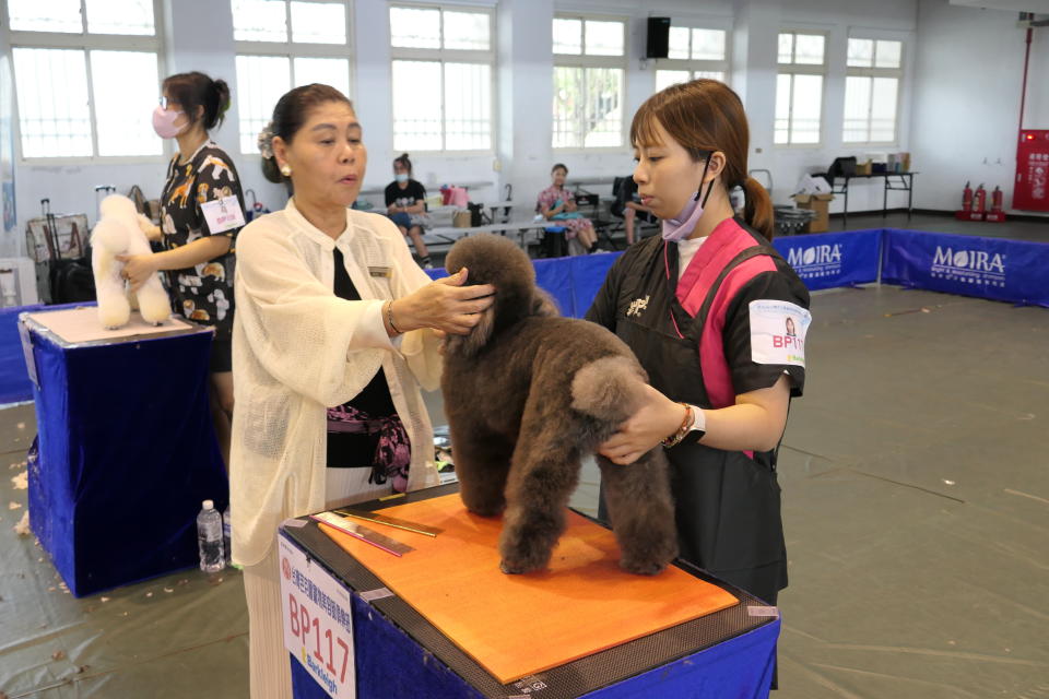 日本首席美容技能審查員HiGa Naomi比嘉老師(左)仔細的審查選手的作品，專業度十足 (醒吾提供)