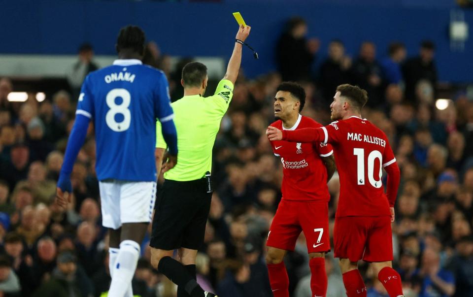 Liverpool's Luis Diaz is shown a yellow card by referee Andrew Madley