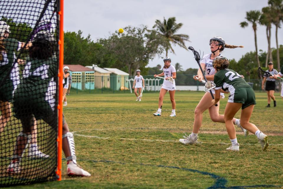 St. Edward's MK Watson (3) shoots past Melbourne’s Avery Colbert (24) Melbourne in a high school girls lacrosse game Wednesday, April 3, 2024, in Indian River County.