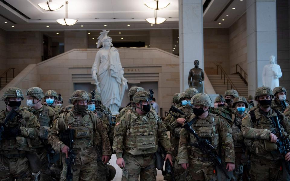 Members of the National Guard prepare in the Capitol Visitors Center on Capitol Hill in Washington, DC, January 13, 2021, ahead of an expected House vote impeaching US President Donald Trump. - The Democrat-controlled US House of Representatives on Wednesday opened debate on a historic second impeachment of President Donald Trump over his supporters' attack of the Capitol that left five dead.Lawmakers in the lower chamber are expected to vote for impeachment around 3:00 pm (2000 GMT) -- marking the formal opening of proceedings against Trump. - BRENDAN SMIALOWSKI/AFP via Getty Images