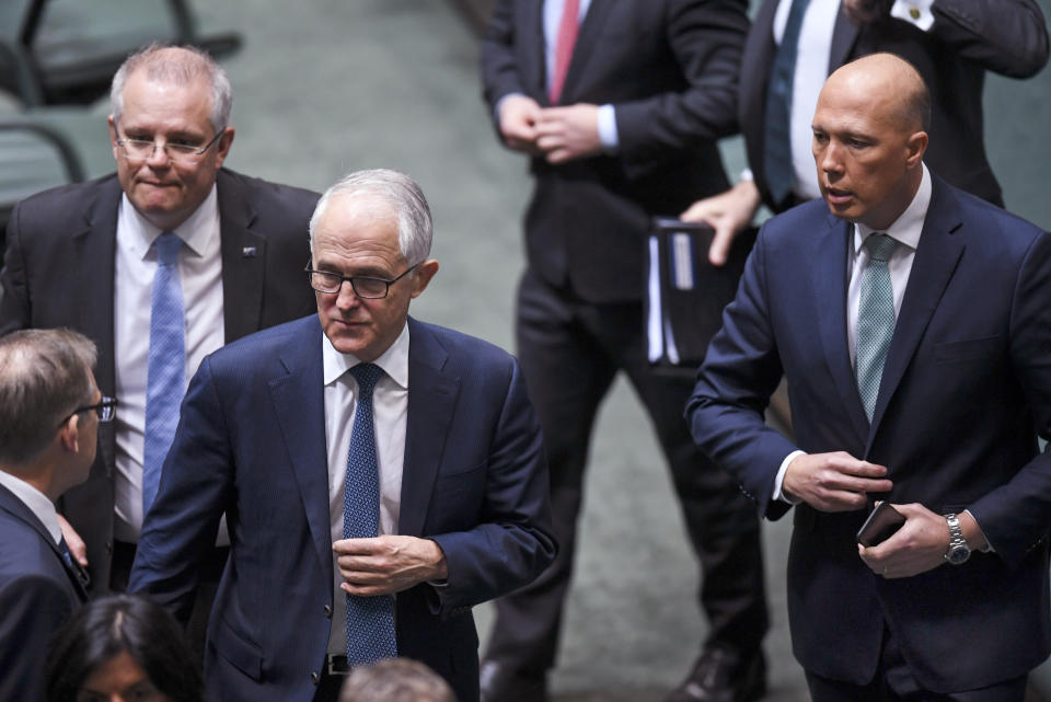 Australian Federal Treasurer Scott Morrison, second left, Prime Minister Malcolm Turnbull, center, and former Home Affairs Minister Peter Dutton, right, leave the chamber at Parliament House in Canberra, Thursday, Aug. 23, 2018, after a vote to refer former Dutton to the High Court to determine whether he is eligible to be a lawmaker, Thursday, Aug. 23, 2018. Three senior Cabinet ministers have told Turnbull he has lost his government's support and must hold an internal ballot to elect a new leader quickly. (Lukas Coch/AAP Image via AP)