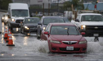 Cars go through a deep puddle at the Garden Grove (22) Freeway exits at Haster Street in Garden Grove, Calif., Friday, Jan. 20, 2017. (Jeff Gritchen/The Orange County Register via AP)