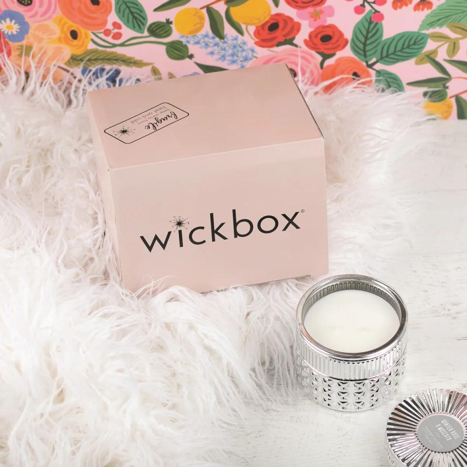 white candle next to pink box