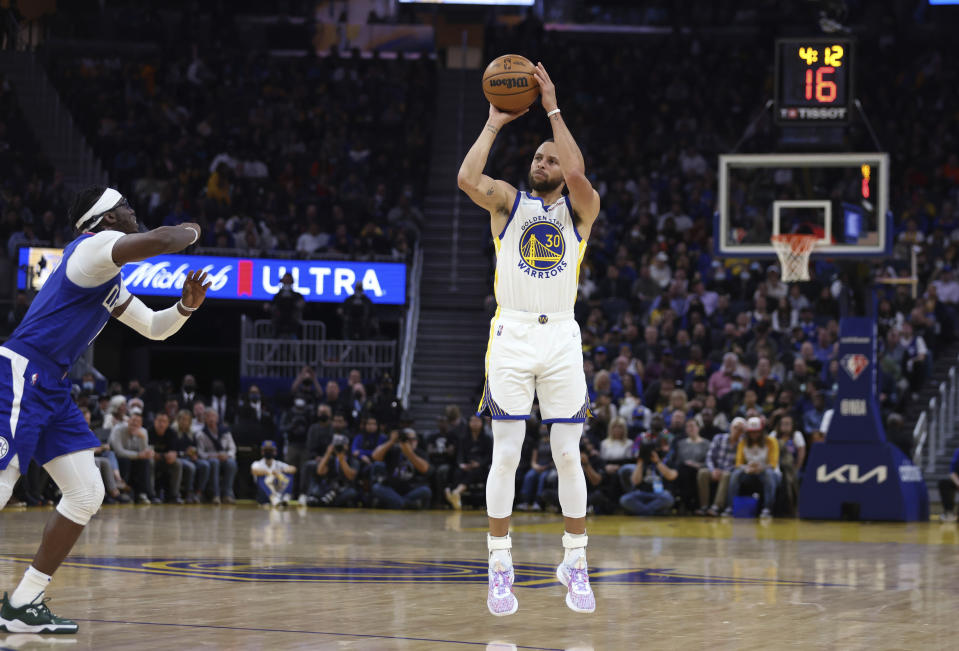 Golden State Warriors guard Stephen Curry (30) shoots against Los Angeles Clippers guard Reggie Jackson, left, during the first half of an NBA basketball game in San Francisco, Tuesday, March 8, 2022. (AP Photo/Jed Jacobsohn)