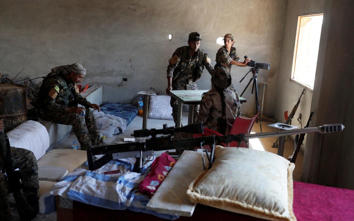 Kurdish fighters from the People's Protection Units (YPG) talk in a sniper position located in a house in Raqqa, Syria June 18, 2017. - REUTERS